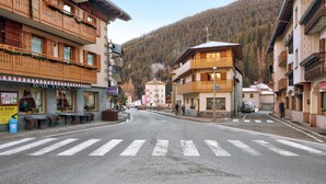 Une vue de rue avec des bâtiments, un passage piéton et une chaîne de montagnes en arrière-plan.