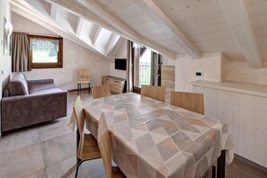 Una habitación con una cama, un sofá, una mesa de comedor y un televisor.