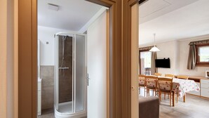 Un interior modern amb dutxa, zona de menjador i cuina.