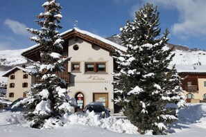 A snow-covered building with a sign reading 'Arcobaleno.'