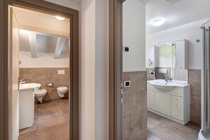 Une salle de bain équipée d’une douche, d’un lavabo, de toilettes et d’un bidet.