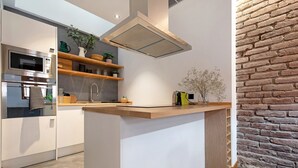 Una cocina moderna con horno empotrado, microondas y electrodomésticos de acero inoxidable.