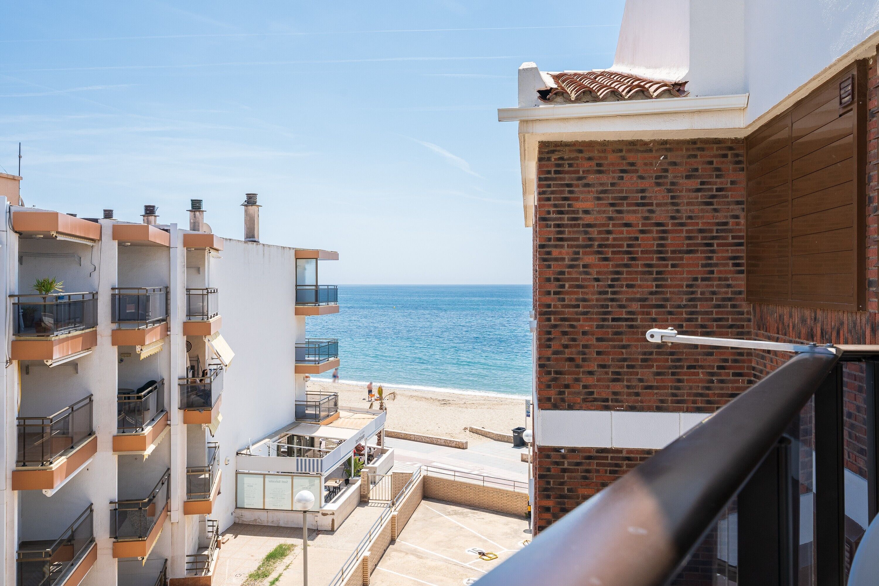 Un immeuble à plusieurs étages doté de balcons donnant sur une plage.