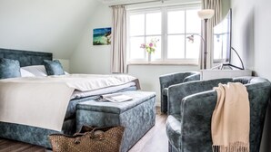 A bedroom with a bed, a desk, and two chairs. - House Rose, luxury vacation home in Fuhlendorf for 4 people with sauna and beach chair (Fuhlendorf)