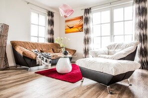 A modern living room with a sofa, armchair, and coffee table.