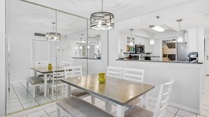 Una cocina moderna con armarios blancos, una isla central e iluminación colgante.