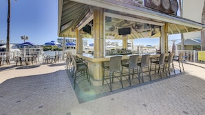 An outdoor bar with a view of the marina, featuring a bar counter, seating, and a sign for 'Cruzan Rum Shack'.