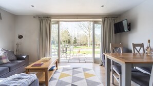 Un salon moderne comprenant un canapé, une table basse et un coin repas avec une table et des chaises.