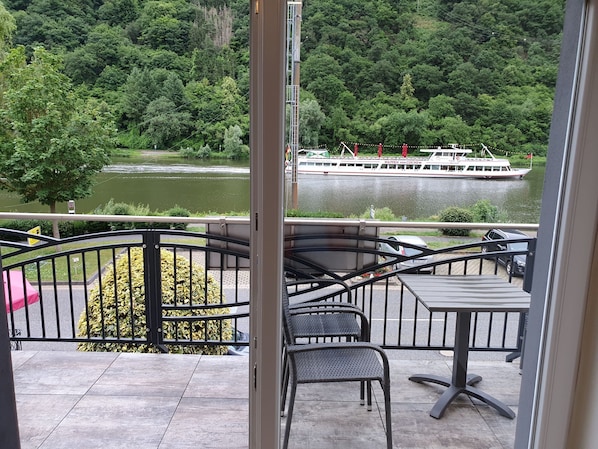 A balcony with a view of a river and a boat.