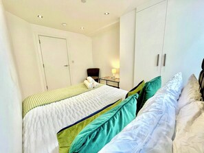 A hotel room with two beds, a desk, and a chair.