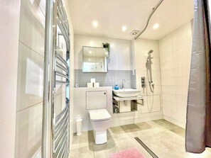 Un baño moderno con inodoro, lavabo y ducha.