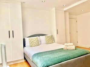 Un dormitorio con cama, armario y radiador.
