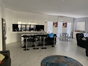 Enjoy socializing at the central island with bar stools in this stylish living area.