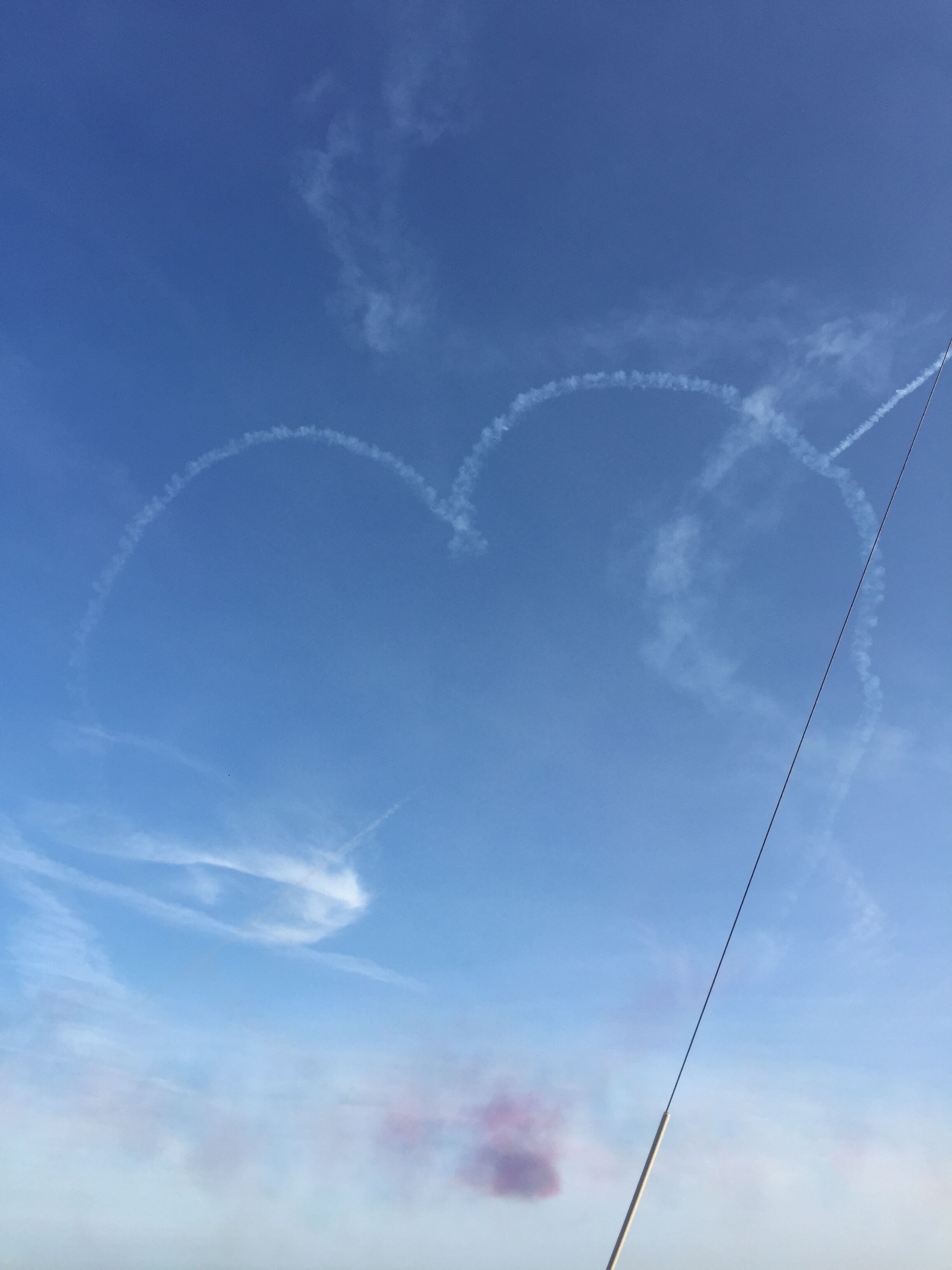 Cielo azul despejado con estelas de condensación que forman corazones.