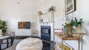 A living room with a television, fireplace, white walls, and a plant. - The Anchor House - Perfect Gem in the centre of Port Fairy (Port Fairy)