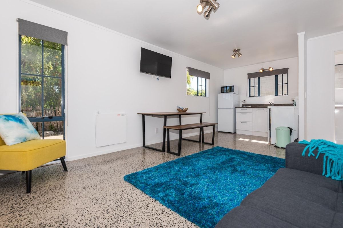A modern living space with a kitchen, dining area, and seating.