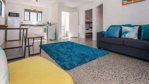 A modern apartment with a kitchen, dining area, and living room. - Ngongotaha Cottage - Hot Tub, Near Skyline (Rotorua)