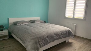 Une chambre à coucher avec un lit, une table de chevet et une fenêtre avec des stores.