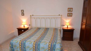 Een slaapkamer met een bed, twee nachtkastjes en een bedbank.