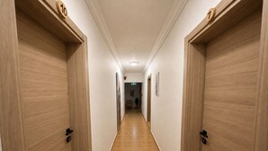 A hallway with wooden doors, numbered 7 and 10, leading to a room. - Eucalyptus Pension (Kas)