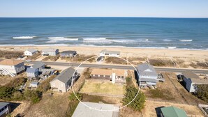 An aerial view of a coastal residential area with houses, a beach, and a road. - Dawn Patrol 4 Bedroom Home in Kitty Hawk (Kitty Hawk)
