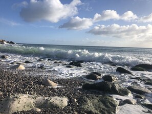Una playa rocosa con olas rompiendo en la orilla.