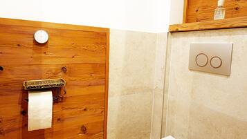 Een douche, handdoeken, zeep, toiletpapier