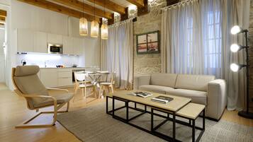 A modern living room with a sofa, coffee table, and a dining area with chairs and a table.