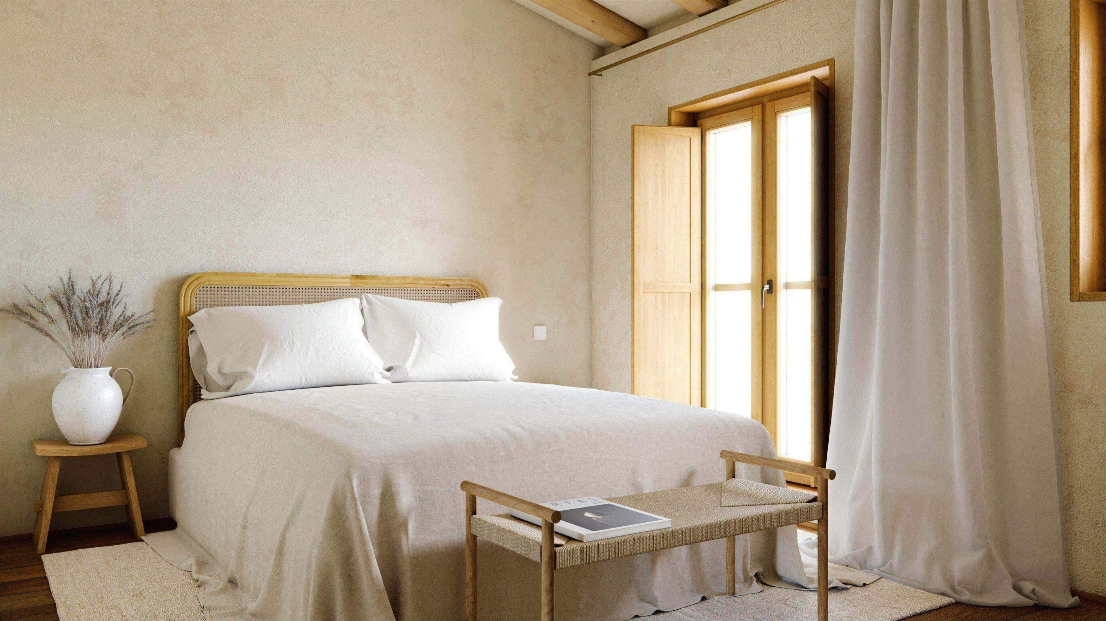 Una camera da letto con un letto, un comodino con un libro, uno sgabello, un vaso con piante essiccate e una finestra con tende.