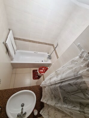 Bathtub, hair dryer, towels, toilet paper