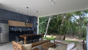 A modern kitchen with a dining area and a seating area with a view of the garden.