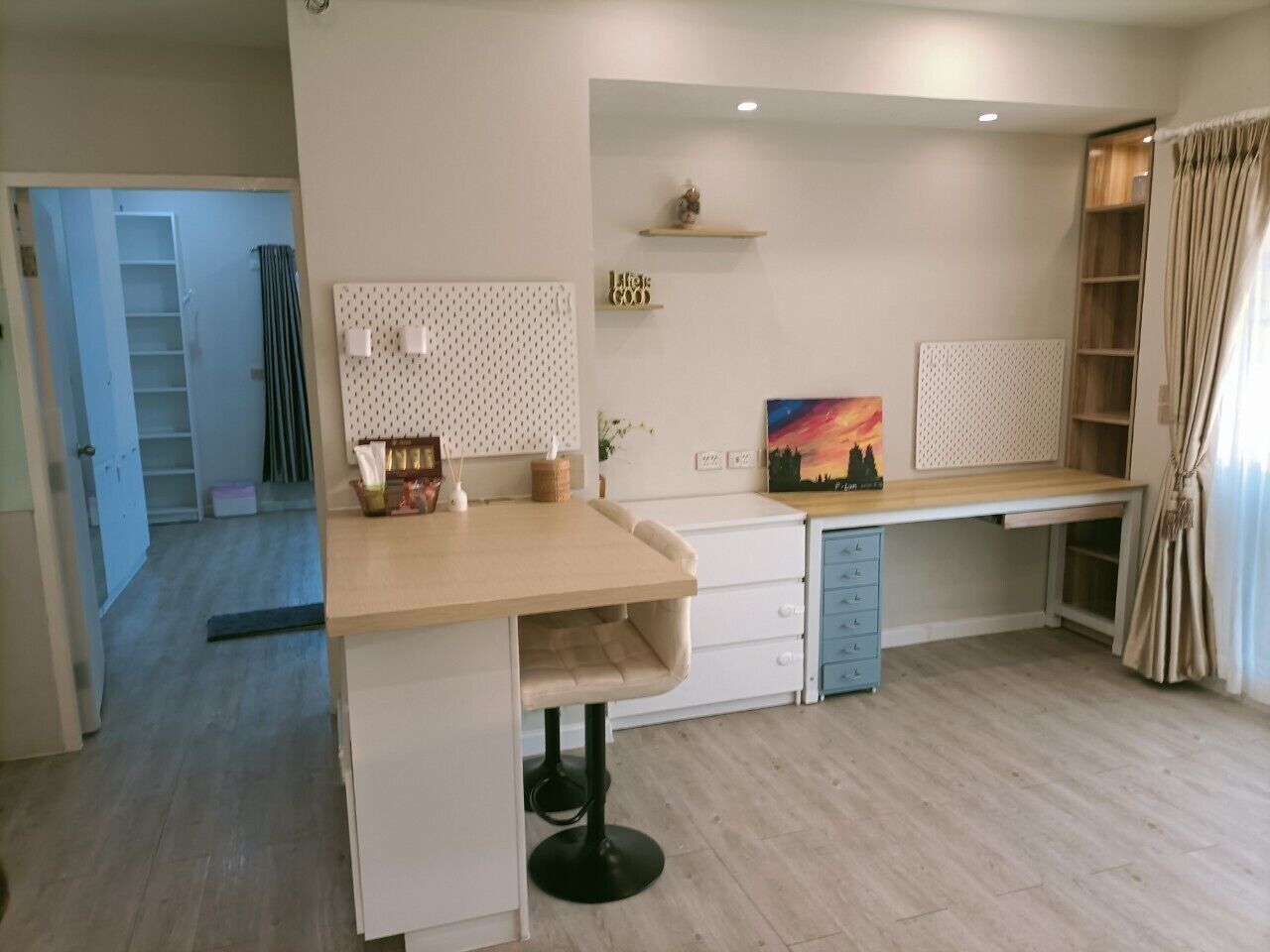 A modern kitchen with a wooden countertop, white cabinets, and a built-in dishwasher.