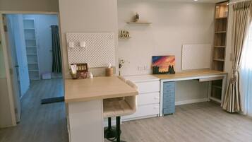 A modern kitchen with a wooden countertop, white cabinets, and a built-in dishwasher.