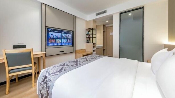 A hotel room with a bed, a desk, a television mounted on the wall, and a wardrobe. - Super 8 (Ningde Wanda Plaza) (Ningde)