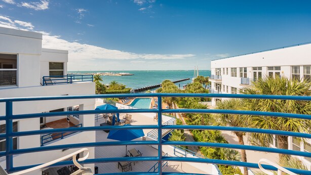 A modern hotel with a pool area, outdoor seating, and a view of the sea. - Sweet's Spot at The Truman Annex in Key West (Key West)