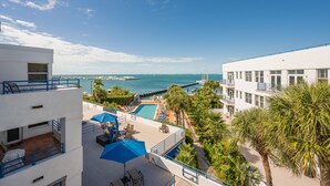 A resort with a pool, lounge chairs, and a view of the sea. - Sweet's Spot at The Truman Annex in Key West (Key West)