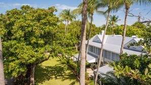 A house surrounded by lush greenery and palm trees. - Sweet's Spot at The Truman Annex in Key West (Key West)