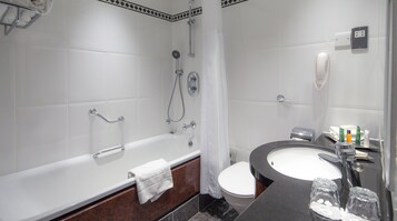 Un bagno moderno con vasca, servizi igienici e lavandino.