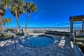 Relax by the serene pool surrounded by palm trees and a tranquil beach.