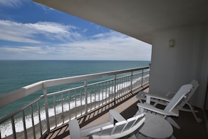 Enjoy the ocean view from this balcony with a comfortable seating area.
