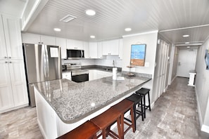 Enjoy cooking in this well-lit kitchen with a large island and stainless steel appliances.