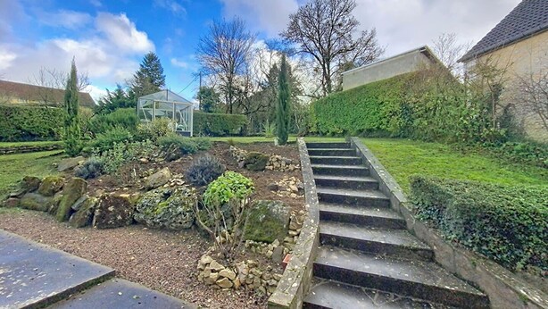 A garden with a stone staircase leading up to a building. - Gîte Lilas Sensation (Thury)