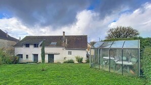 A house with a large glass greenhouse in the backyard. - Gîte Lilas Sensation (Thury)