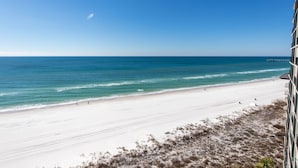 A beach with a clear view of the ocean and a pier in the distance. - Edgewater 2 Br Deluxe Gulf Front, Tower 2. Sleeps 10! (Panama City Beach)