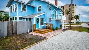 A two-story blue house with a front porch, a wooden deck, and a small balcony. - Upper-Level Duplex with Partial Ocean Views 3BR/2BA (Jacksonville Beach)