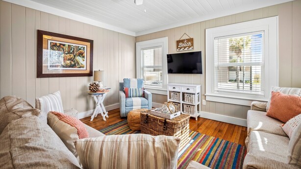 A living room with a fireplace, a television, and a comfortable seating area. - Upper-Level Duplex with Partial Ocean Views 3BR/2BA (Jacksonville Beach)