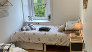 A small, cozy bedroom with a single bed, a window with a view of greenery, a radiator, and a small bedside table with a lamp. - The Ramblers Rest - whole apartment, pet friendly, close to amenities/walks. (Edzell)