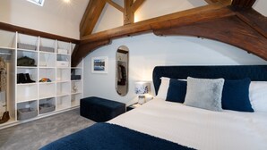 A bedroom with a large bed, a built-in wardrobe, and a skylight. - Old Police Office in Hawkshead by LetMeStay (Ambleside)