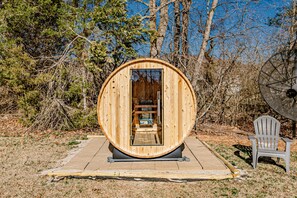 Relax in a serene outdoor setting, surrounded by nature, with access to a sauna and a peaceful retreat.