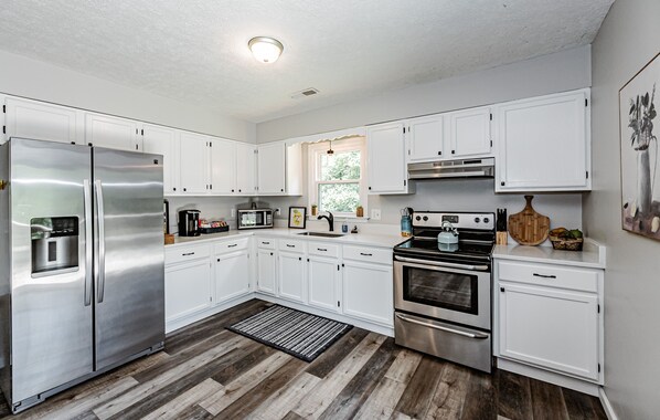 Enjoy cooking in this well-equipped kitchen with a refrigerator, oven, microwave, and kettle.